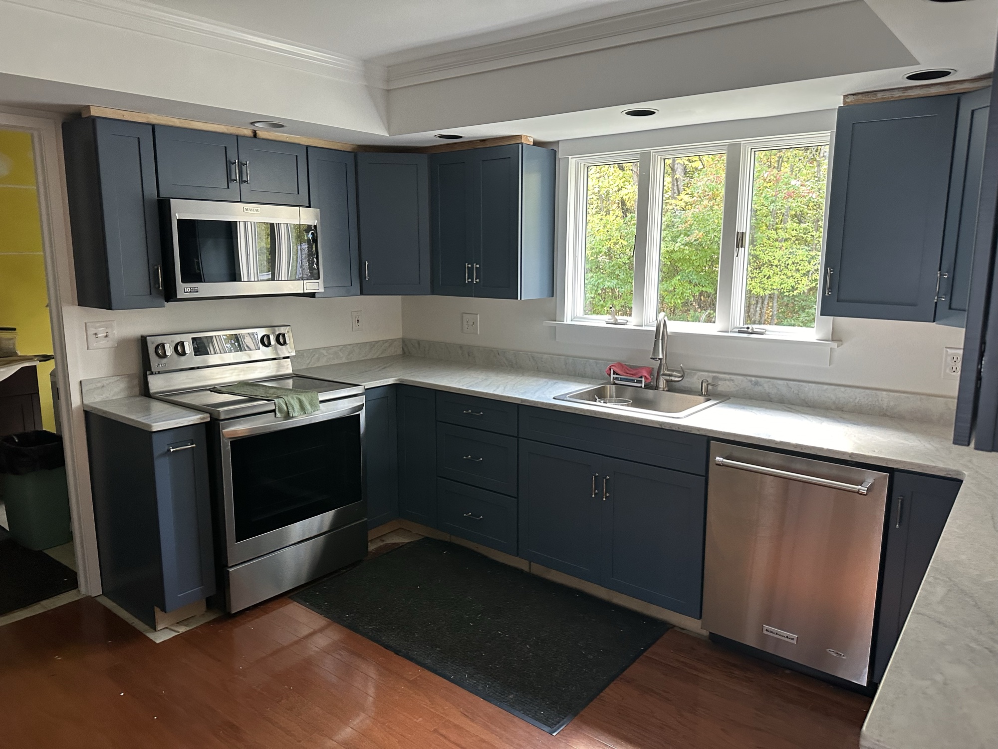 Navy blue cabinet refinishing with stainless steel appliances