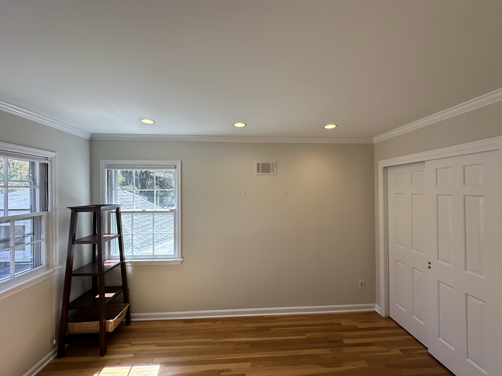 Bedroom with soft gray walls and hardwood floors