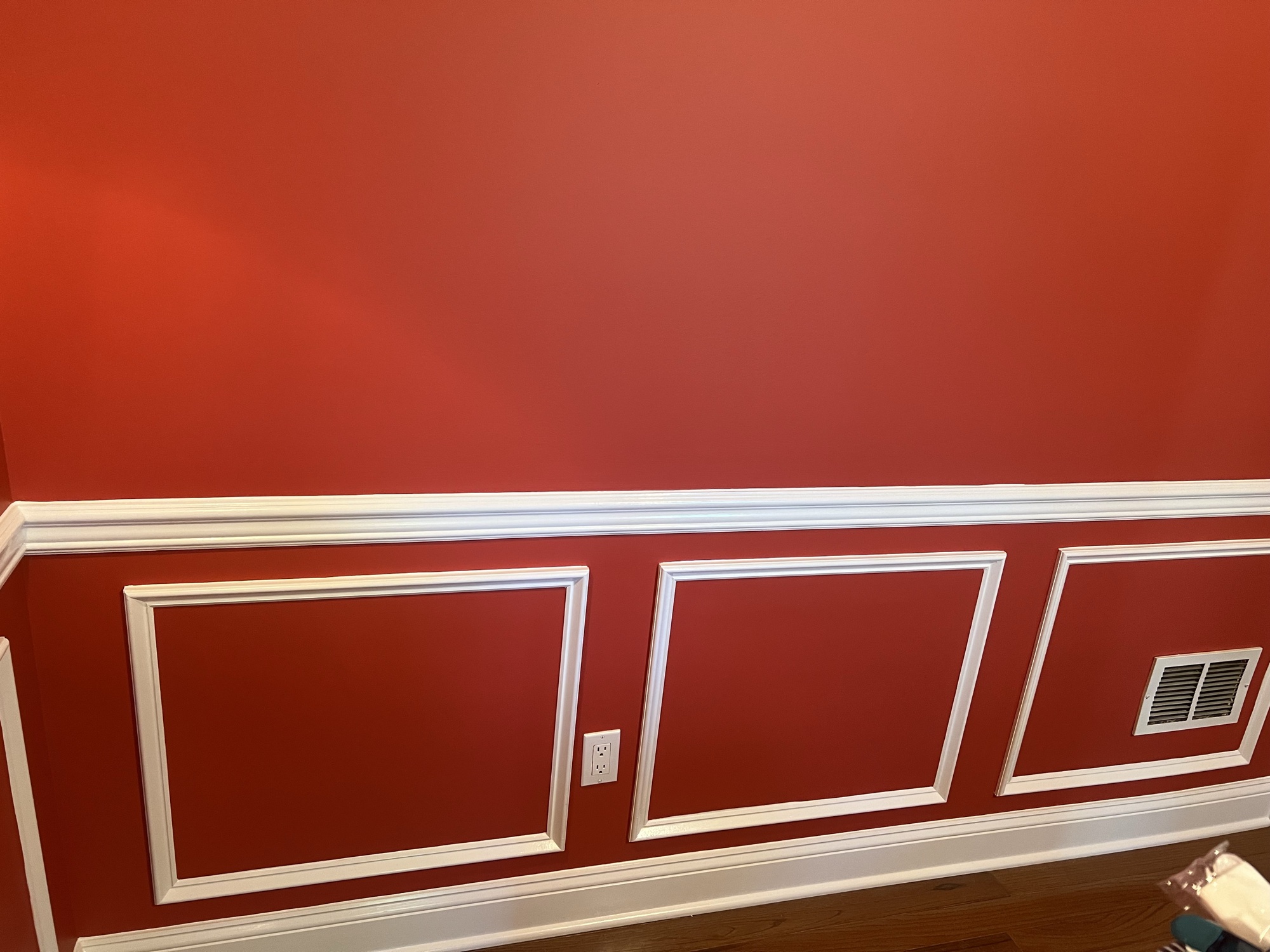 Bold red accent wall with white wainscoting and trim