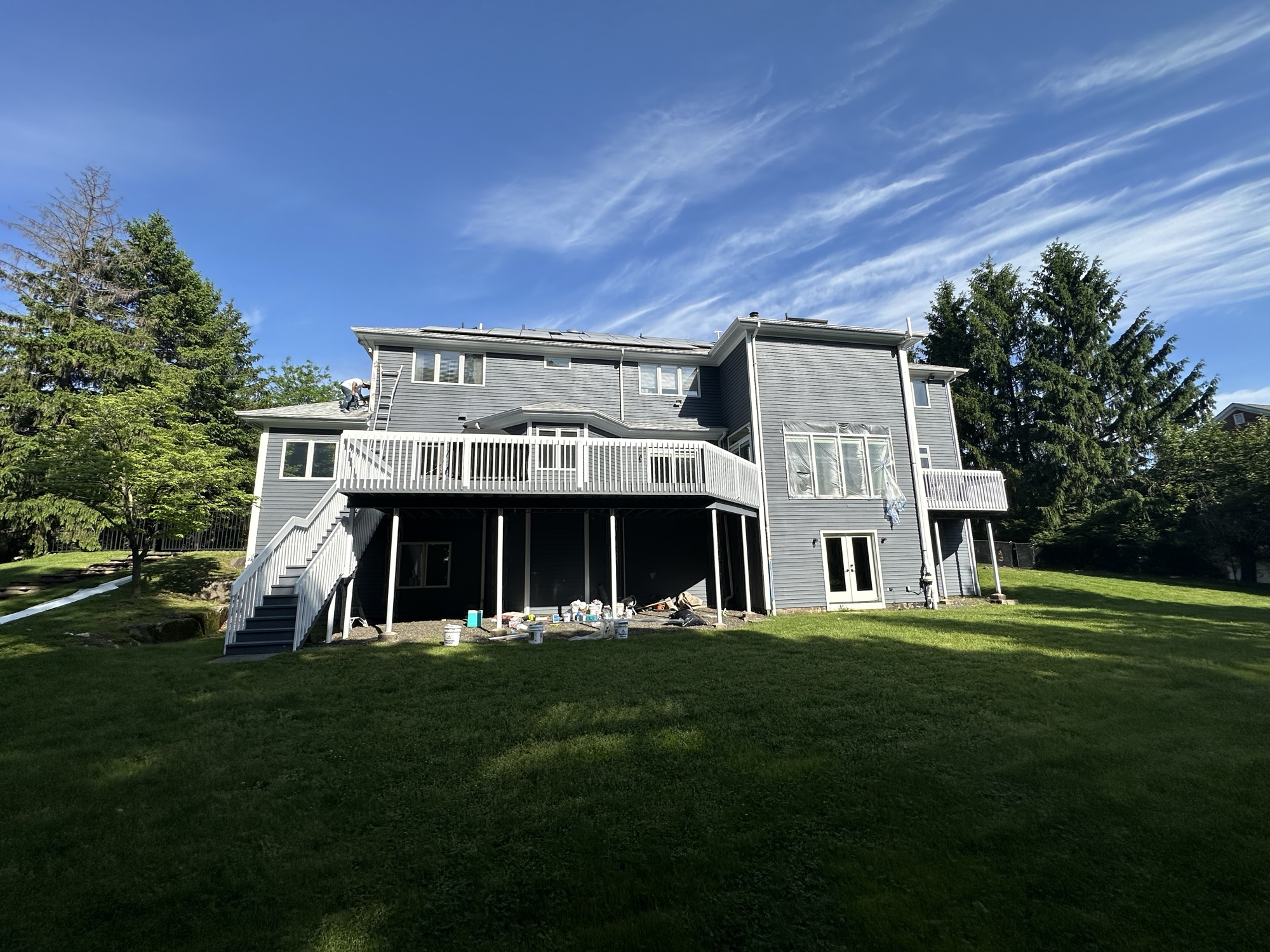 Gray house exterior painting with dramatic sky by J&B Painting
