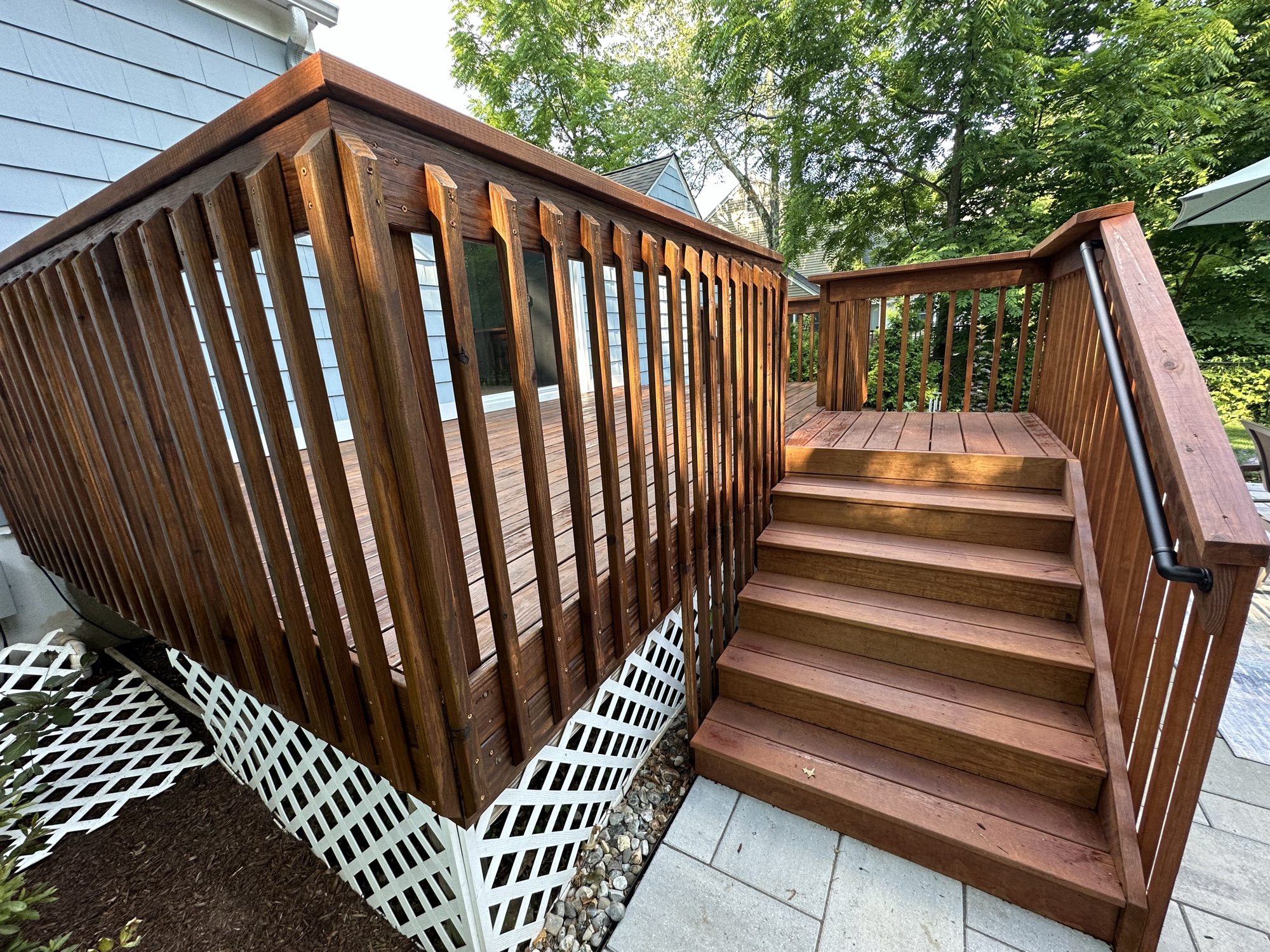 Rich wood deck staining with detailed railing by J&B Painting