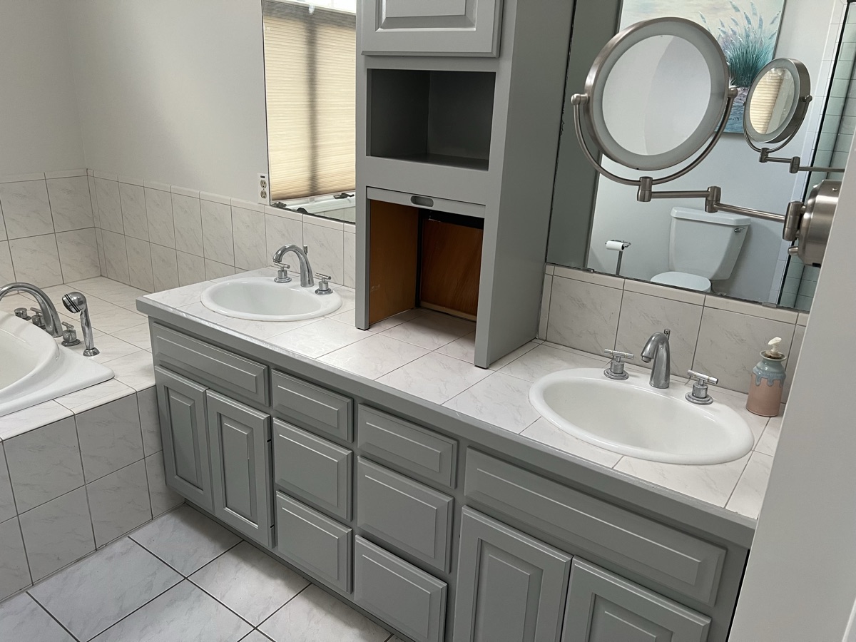 Gray bathroom vanity with dual sinks and mirrors