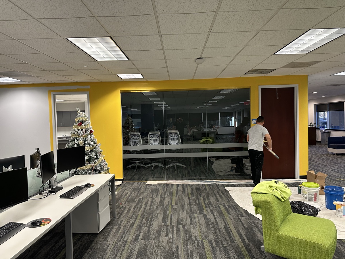 Corporate office yellow accent wall with glass conference room