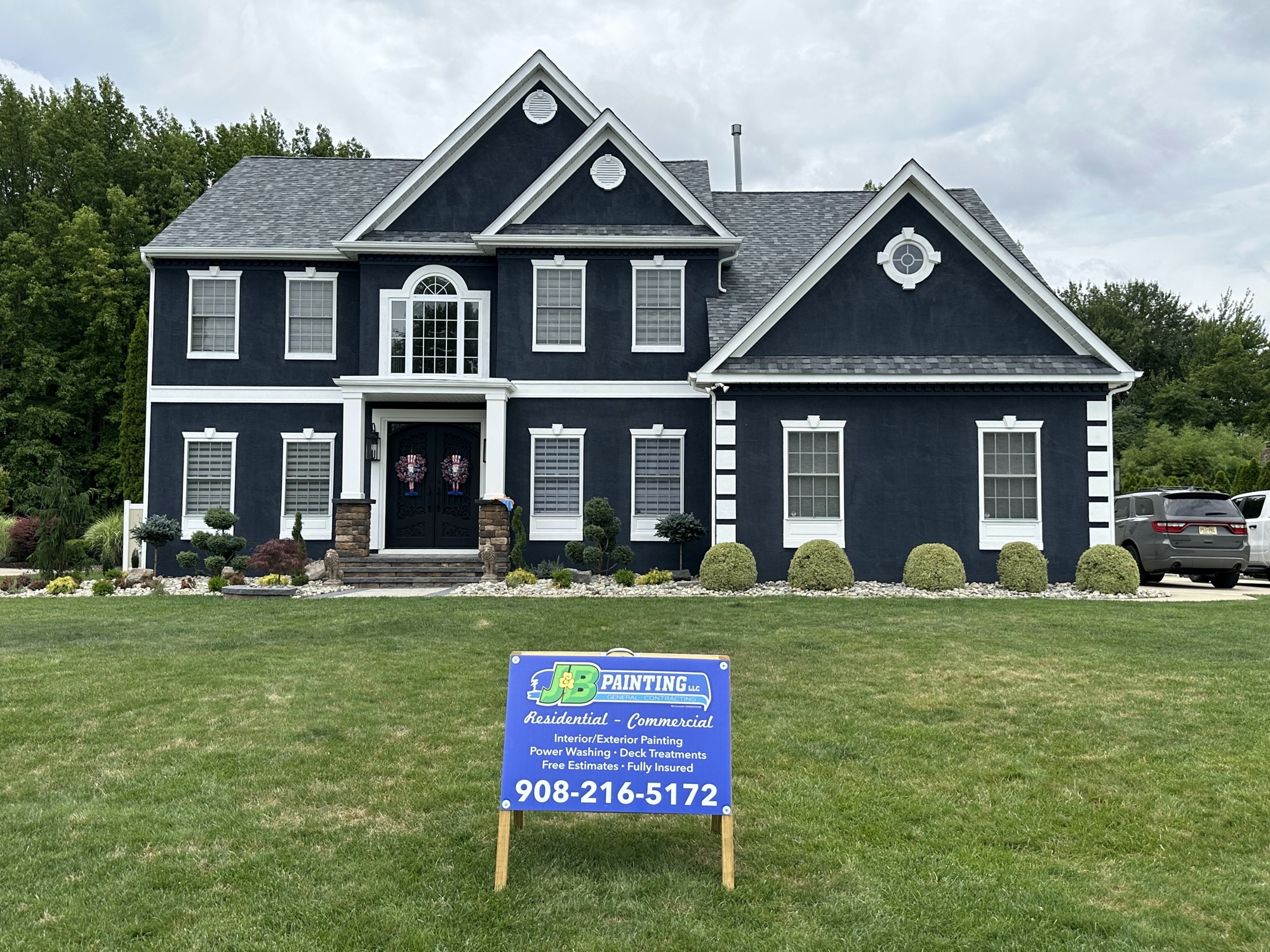 Dark navy colonial exterior painting with J&B Painting sign