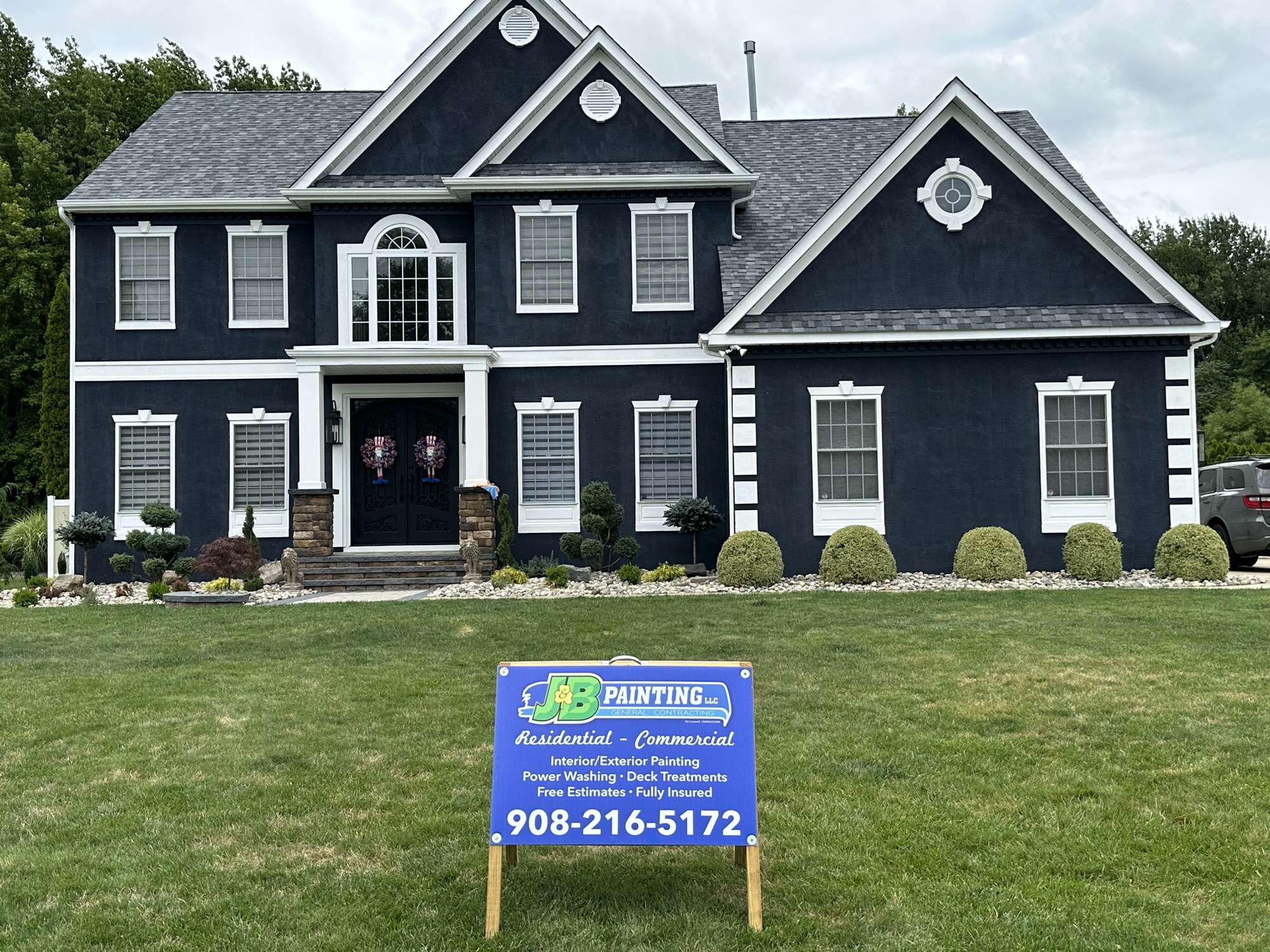 Dark navy colonial exterior painting with white trim by J&B Painting