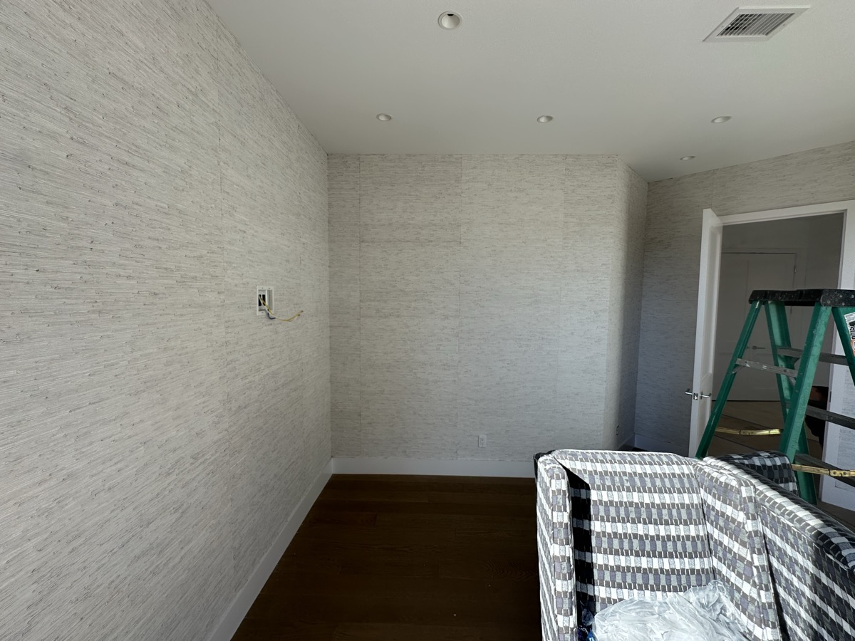 Textured neutral wallpaper installation in living room